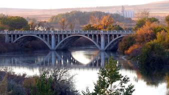 Old Concrete Bridge over calm river at autumn morning