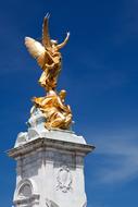 Shiny, gold sculpture of the Angel in sunlight, at the Buckingham Palace in London, England