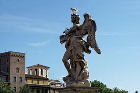 Statue in Rome, Italy, among the green plants and buildings