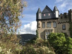 Beautiful castle in sunlight, among the colorful plants, in the Middle Rhine, Germany