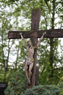 wooden cross and figurine of the crucifixion of Jesus Christ in the cemetery