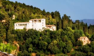 Beautiful Generalife Palace, among the colorful trees on the mountain in Granada, Spain ,under the blue sky