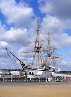 Colorful ship in the dockyard of the sandy beach, under the blue sky with clouds