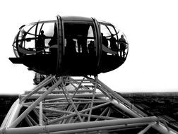 Black and white photo with the people in the cabin of the London Eye, in London, England