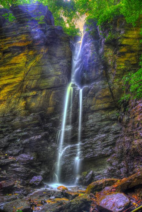 Beautiful waterfall on the colorful rocks with plants