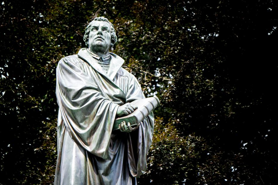 Statue of Marthin Luther with Bible at colorful background