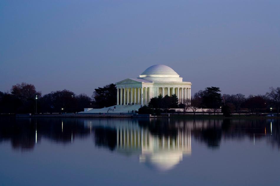 Beautiful Jefferson Memorial with columns, on the shore with trees, with the reflection in the water in Washington, USA