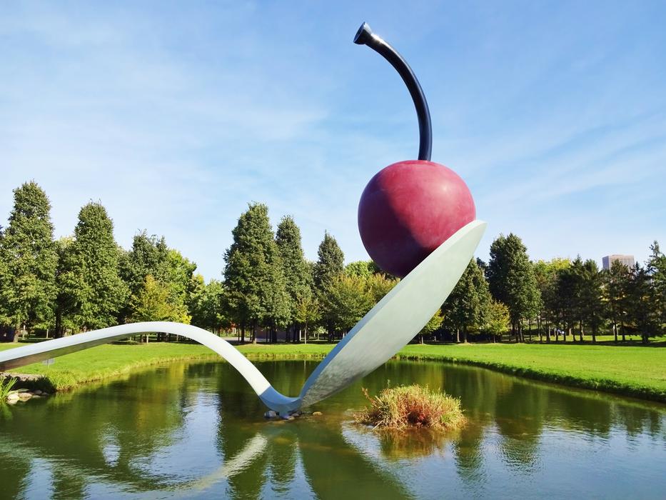 sculpture of cherries in a spoon on the background of the park