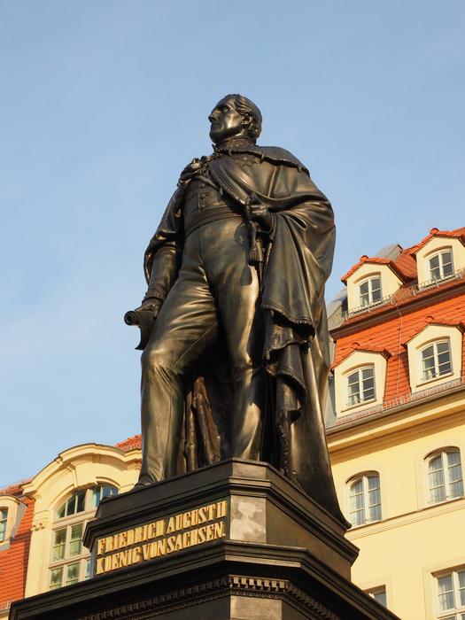 Martin Luther Monument, near the colorful and beautiful building in Dresden, Germany, at blue sky on background