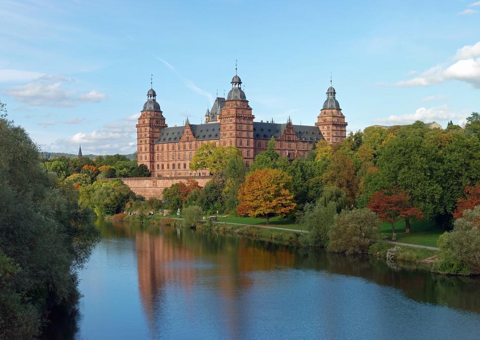Beautiful and colorful castle, among the colorful trees, on the shore of the river in Aschaffenburger, Bavaria, Germany