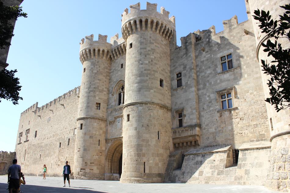 People, near the beautiful castle in light, in Rhodes, Greece, under the blue sky