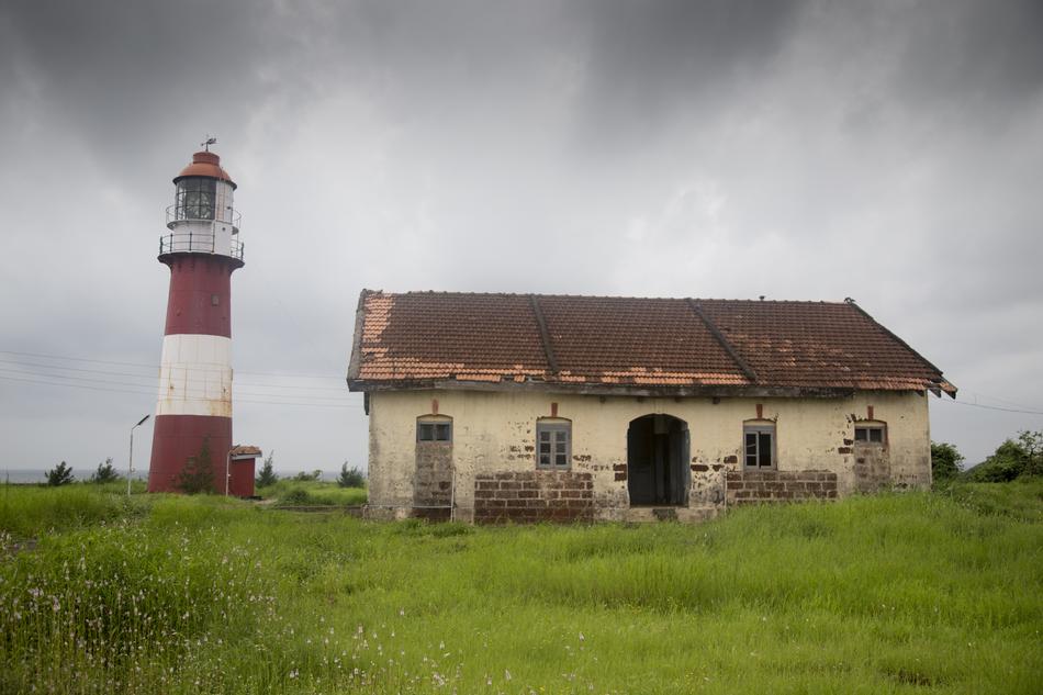 lighthouse near the old building on the hill
