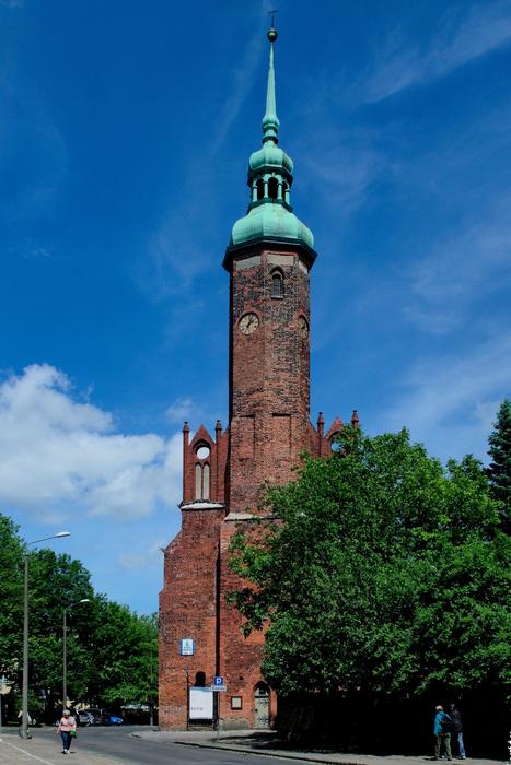 Colorful and beautiful church, with the green dome, in Slupsk, Poland, among the green trees