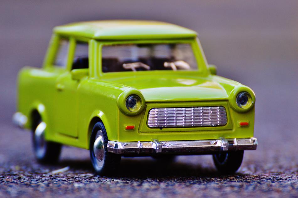 Model of the shiny, green Trabi car, on the colorful ground