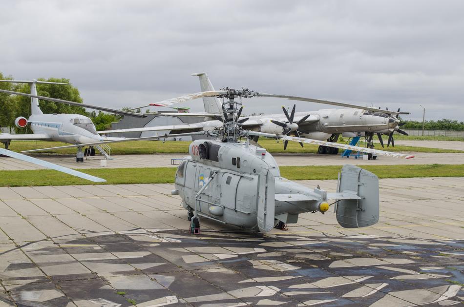 Helicopter and planes in the Military Museum, outdoors, under the clouds