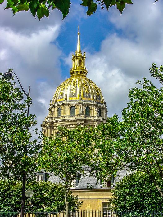 church building with golden dome behind green trees