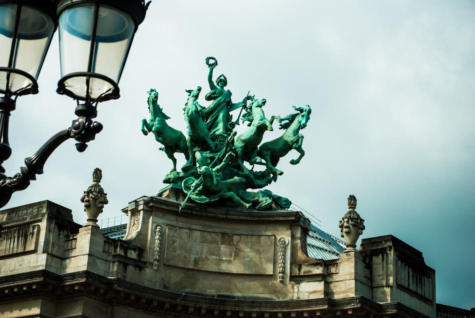 Beautiful statue near the lantern in Paris, France, under the sky with clouds