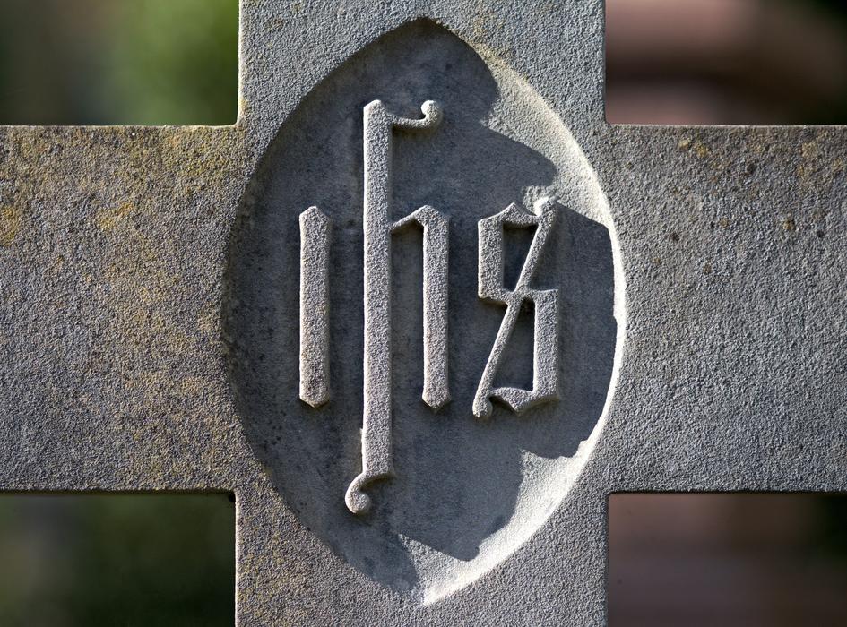 cristogram on a stone cross in a cemetery