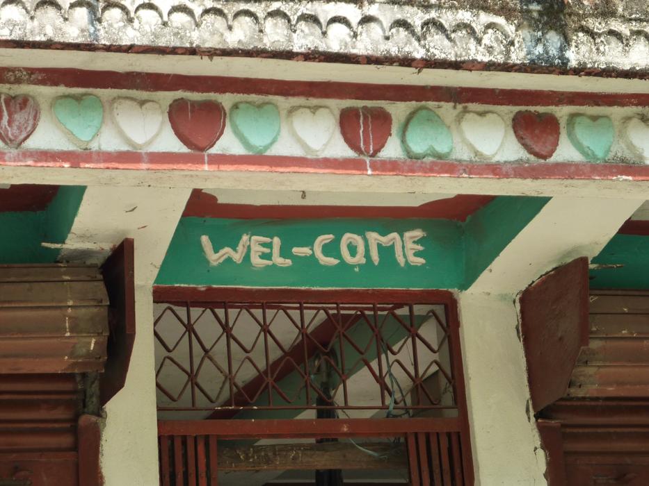 wel-come lettering over entrance to old asian building