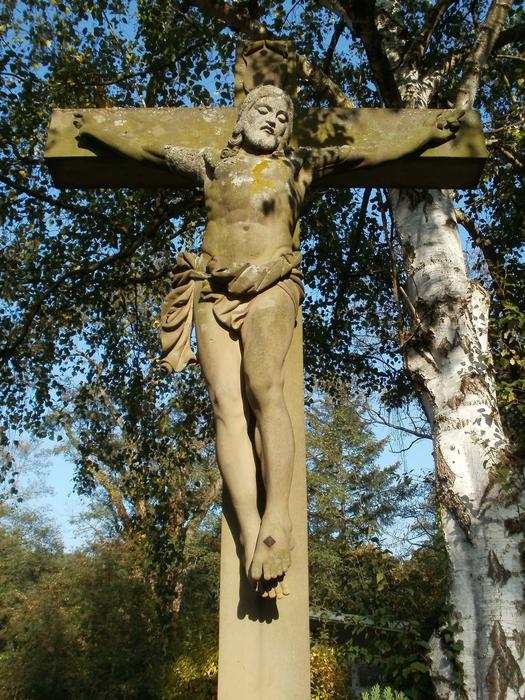 Cross at the cemetery in Hockenheim, Germany, among the colorful plants
