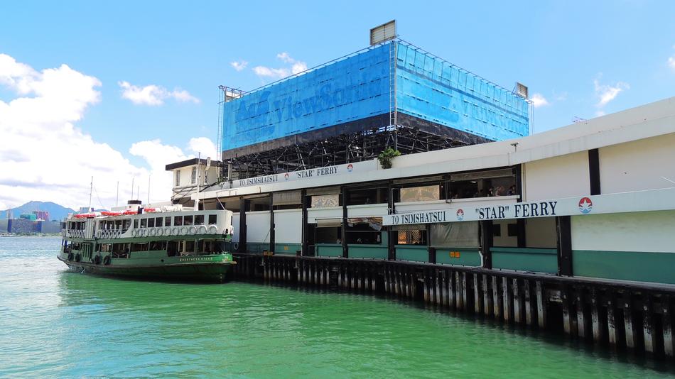 Buildings near the green water, in Hongkong, under the blue sky with white clouds