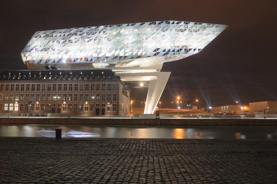 Shiny, colorful office building among the other buildings, in Antwerp, Belgium, in the evening