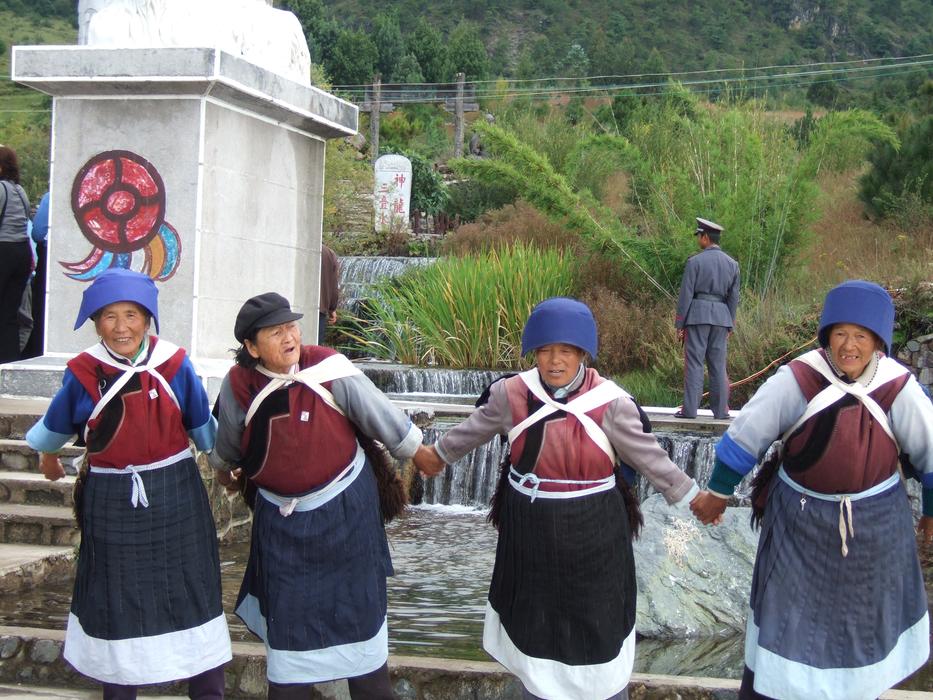 Women in the colorful costumes, near the colorful plants in China