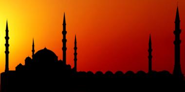 mosque and minarets silhouette at red sunset sky