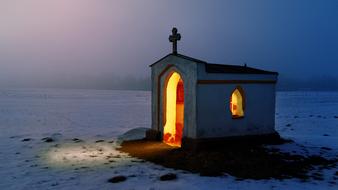 old chapel at night in a snowy landscape
