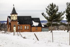 distant view of a wooden church among a snowy landscape