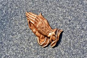 praying hands relief on grey stone