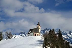 scenic winter Landscape, chapel on hill at snowy mountains