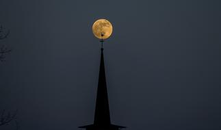 church spire on the background of the bright moon