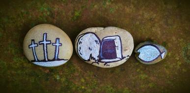 closeup picture of painted crosses and gravestones on pebbles