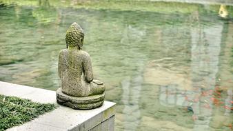 buddha statue near water in chinese temple
