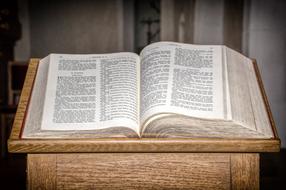 open Holy Book on wooden table