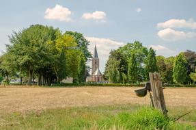 Beautiful and colorful landscape with the church, in the countryside, among the colorful and beautiful plants, under the clouds