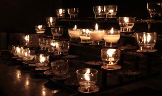 prayer Candles burning in darkness