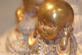 Buddha small gold close-up on blurred background