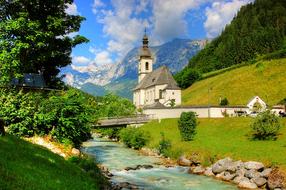 Beautiful church near Ramsauer Arche river, among the green and yellow mountains in Bavaria, Germany