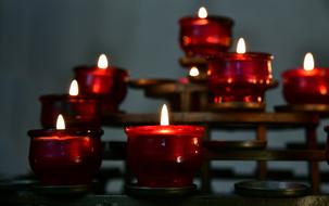 burning red candles in a catholic monastery