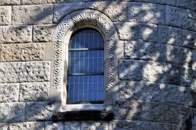 romantic facade with window in the stone wall in light and shadow