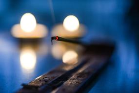 Close-up of the beautiful incense, at blurred background with the burning candles