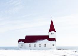 Beautiful, white and red church among the snow, in winter on landscape