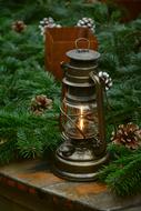 photo of a kerosene lamp and pine branches with cones