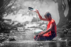 young buddhist Monk pouring water in bowl