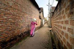 a woman with a bag on her shoulder walks down the street