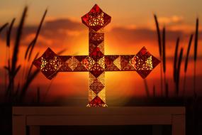 cross on sunset background with blurred background