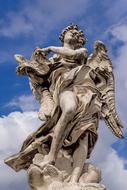 Beautiful statue of the Angel, in sunlight, under the blue sky with white clouds, in Rome, Italy