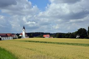 Village with church behind crops field, germany, bavaria